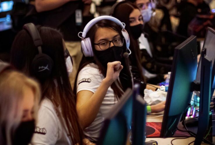 MeL fist bumps her teammates at a LAN tournament wearing a C9 jersey and black mask
